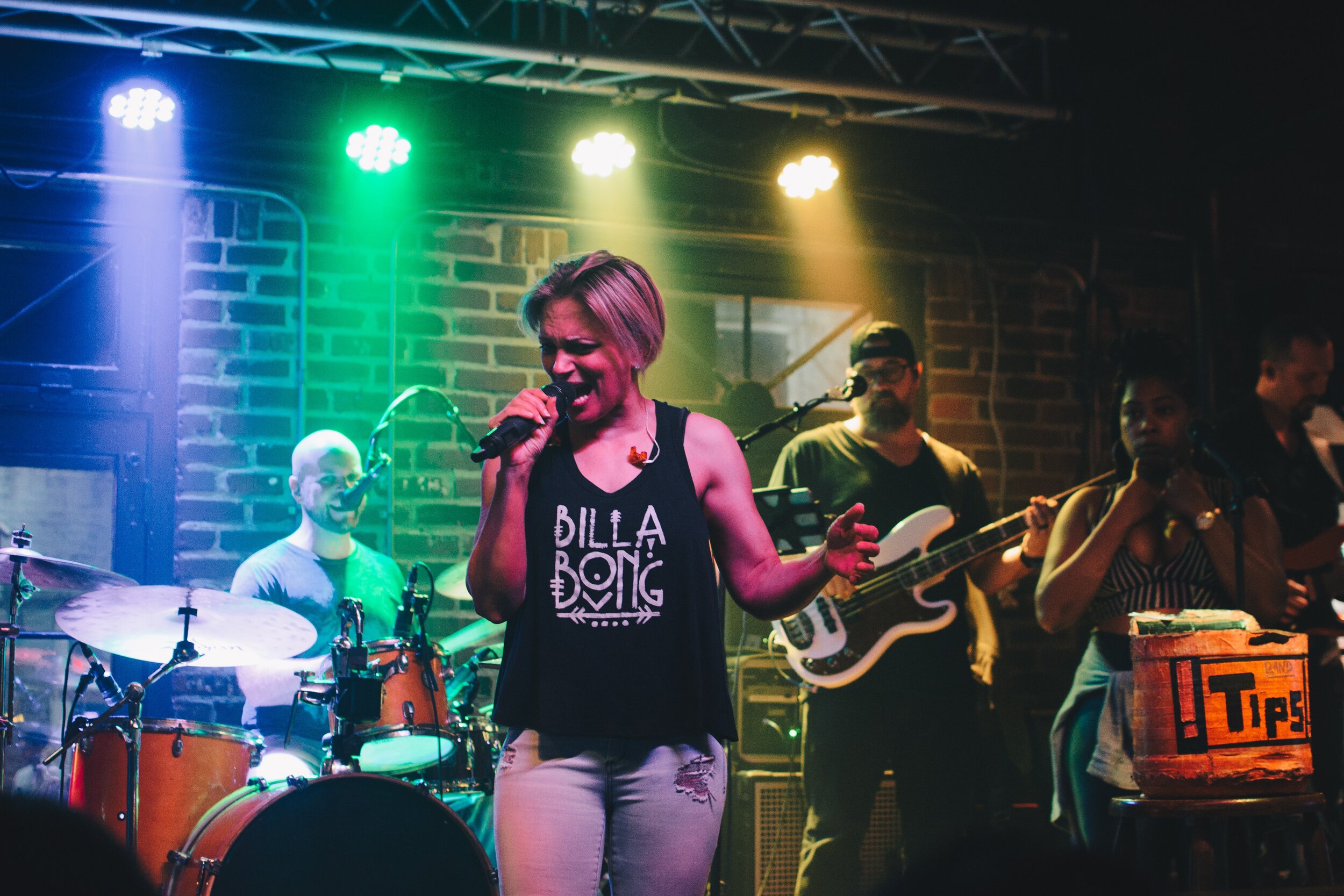 woman singing on stage with band