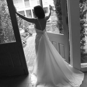 GIRL IN WEDDING DRESS LOOKING OUT WINDOW