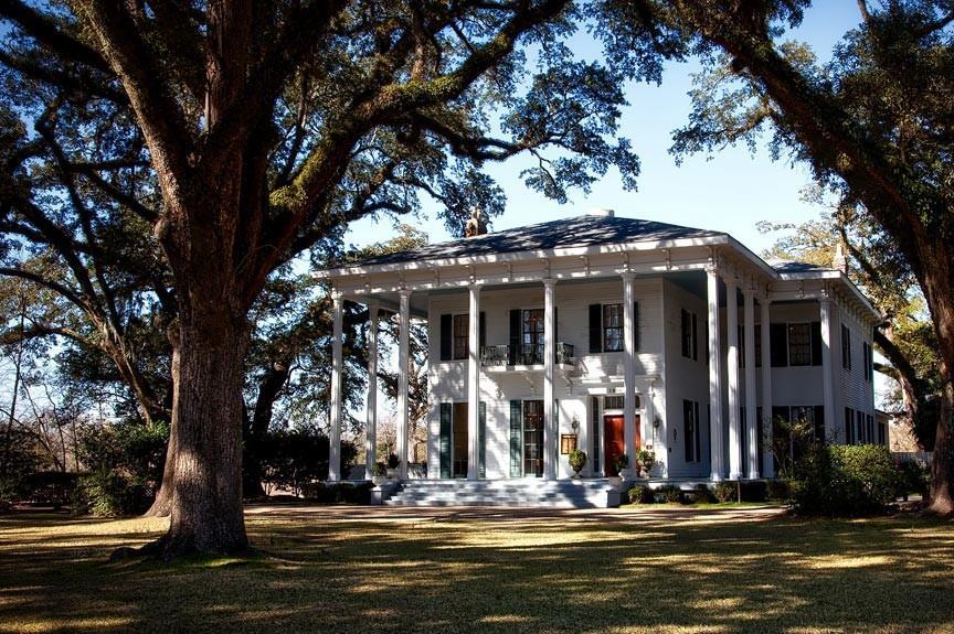 PLANTATION STYLE WHITE MANSION SURROUNDED BY WEEPING WILLOW TREES