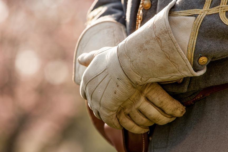 PERSON WITH GLOVES ON FOLDING ARMS